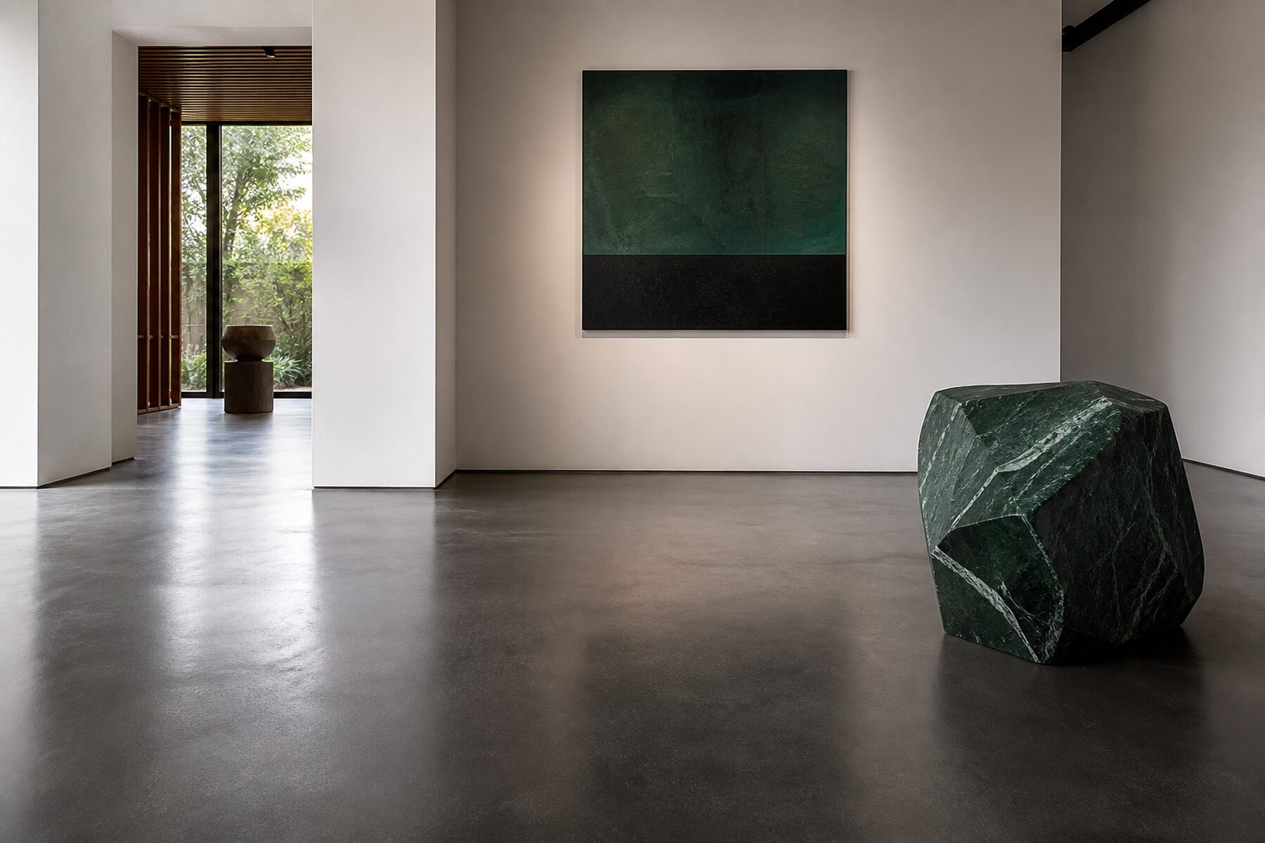 Piso epoxi grafito de reflejo moderado en una galería contemporánea con muros blancos cálidos.
