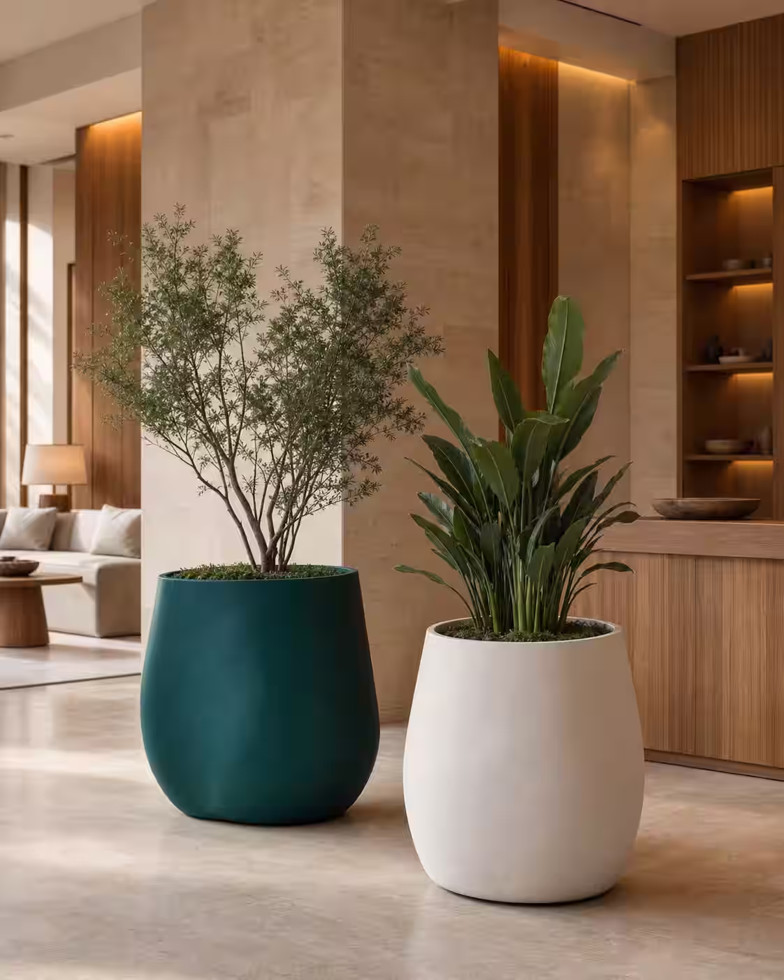 Macetas escultóricas de fibra de vidrio con acabado mate en el lobby de un hotel contemporáneo.