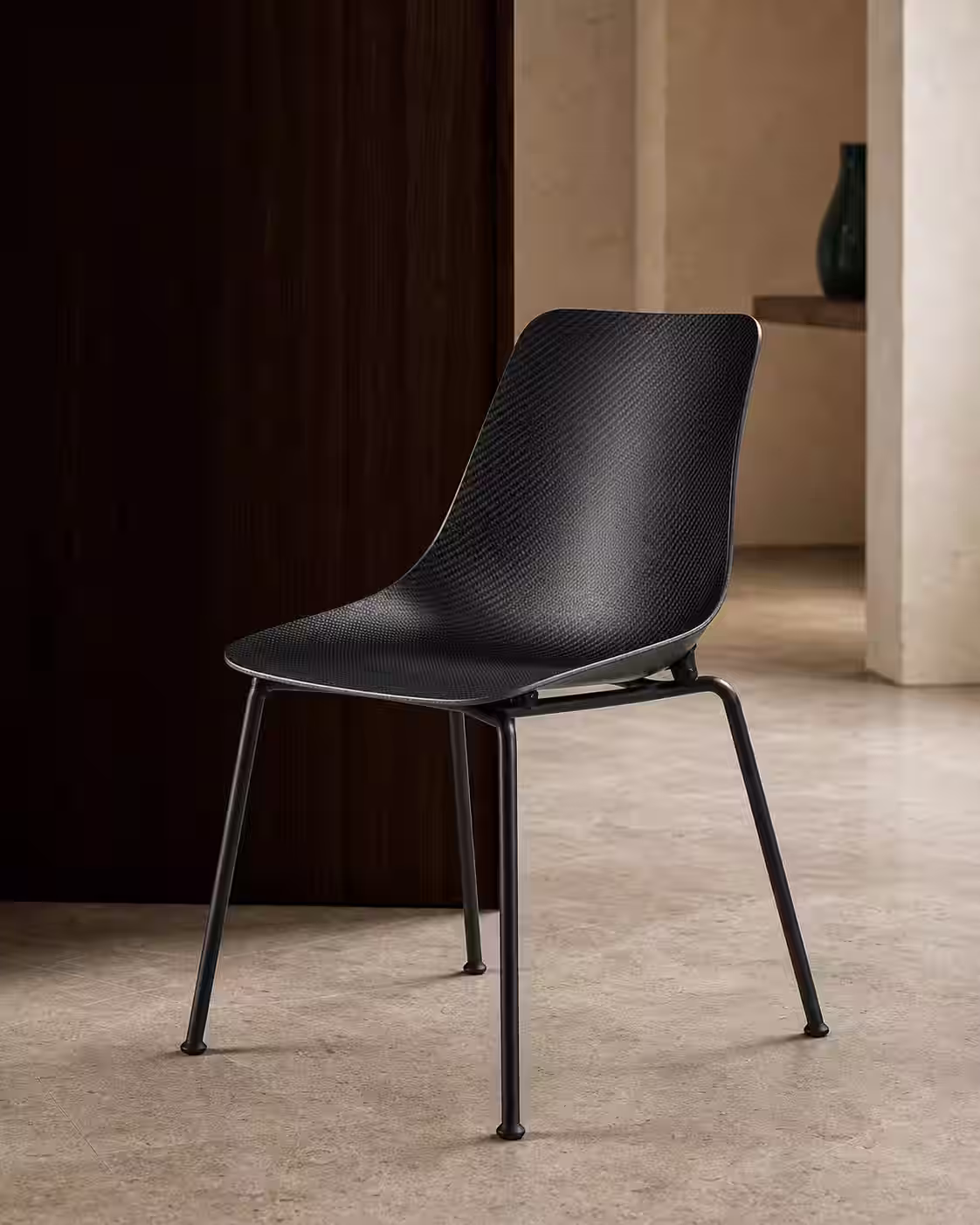 Silla de fibra de carbono con trama continua y acabado satinado en un interior editorial.