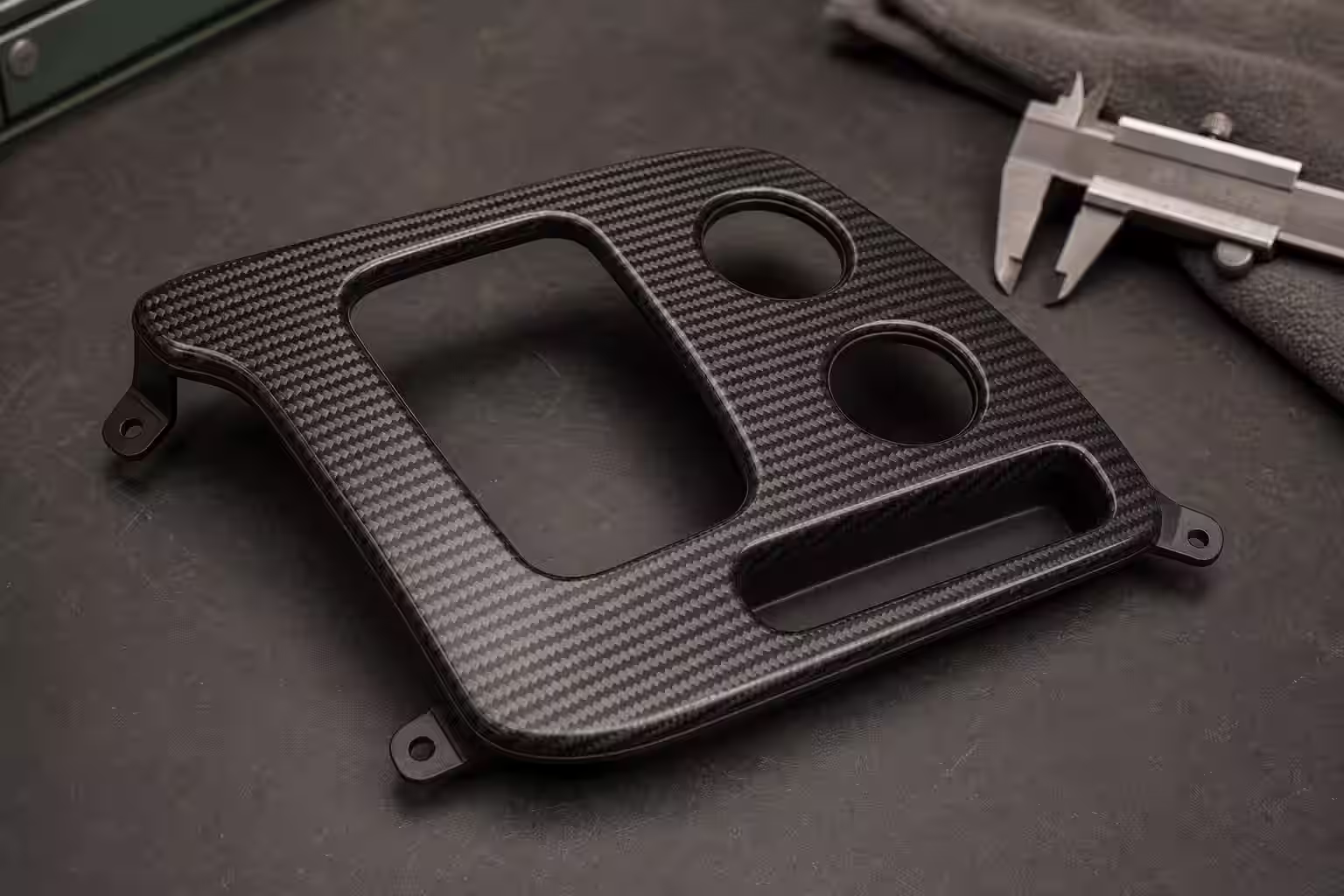 Consola automotriz personalizada de fibra de carbono con acabado satinado y sin marcas visibles.